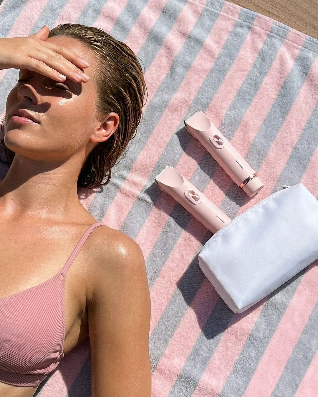The Peach trimmers and travel pouch on a beach towel
